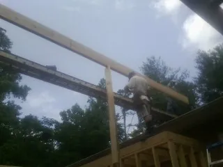 Carpenter setting a ridge beam over a new addition frame — Ice Dam Removal by Roofing Brothers in Prince Frederick