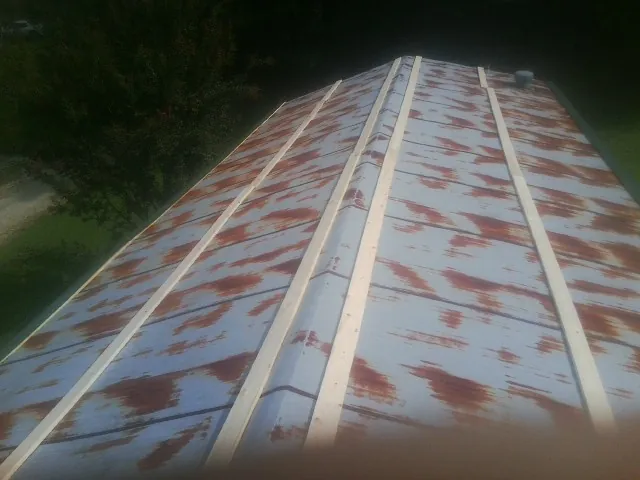 Rusted metal roof panels with new wood purlins before replacement — Storm Damage Roof Repair in Prince Frederick by Roofing Brothers