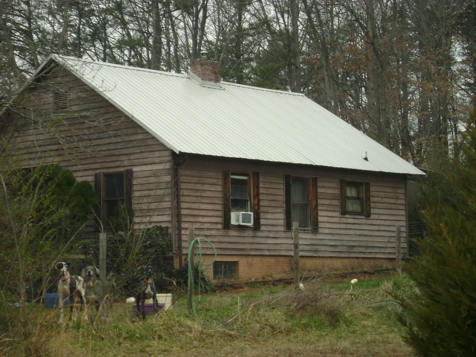 White metal roof on an old wood sided farmhouse, from a Metal Roof Installation job in Prince Frederick